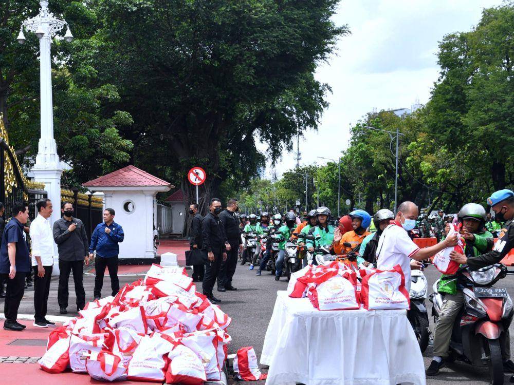 Presiden Joko "Jokowi" Widodo ketika membagikan paket sembako bagi pengemudi ojek daring di depan Istana Negara pada Kamis, 13 April 2023. (Dokumentasi Biro Pers Istana)