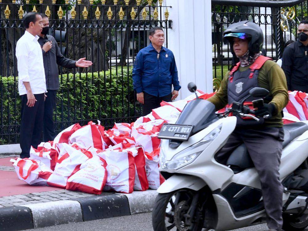 Presiden Joko "Jokowi" Widodo ketika membagikan paket sembako bagi pengemudi ojek daring di depan Istana Negara pada Kamis, 13 April 2023. (Dokumentasi Biro Pers Istana)