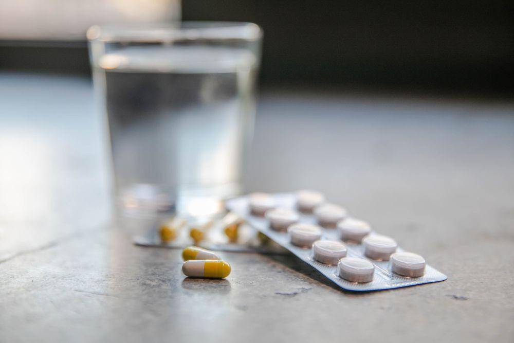 ilustrasi minum obat dengan air putih (unsplash.com/Alexander Polous)