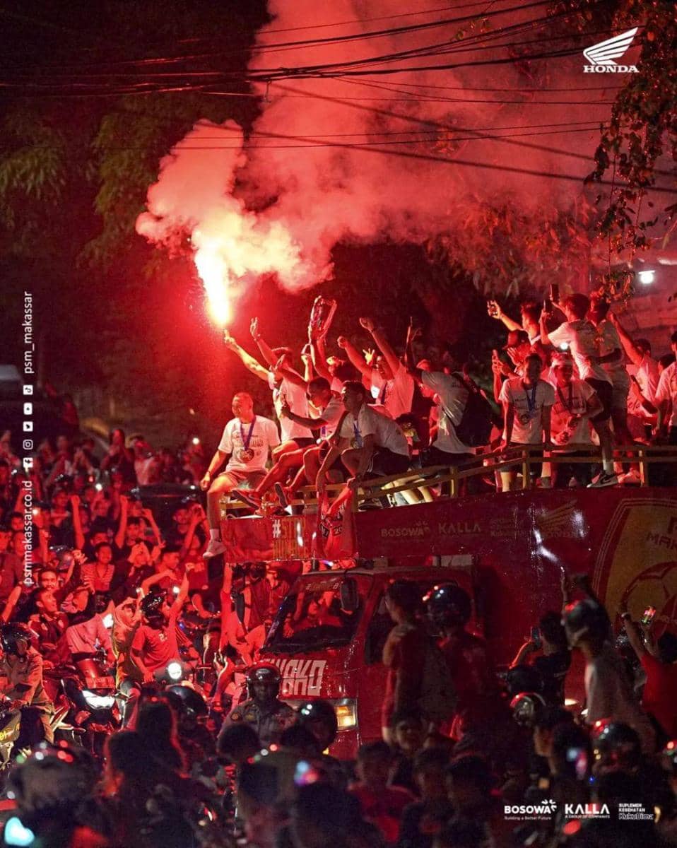 Suporter menyaksikan bus berisi para pemain PSM Makassar dan trofi Liga 1 melintas di Kota Parepare, Minggu malam (16/4/2023). (Instagram/psm_makassar)