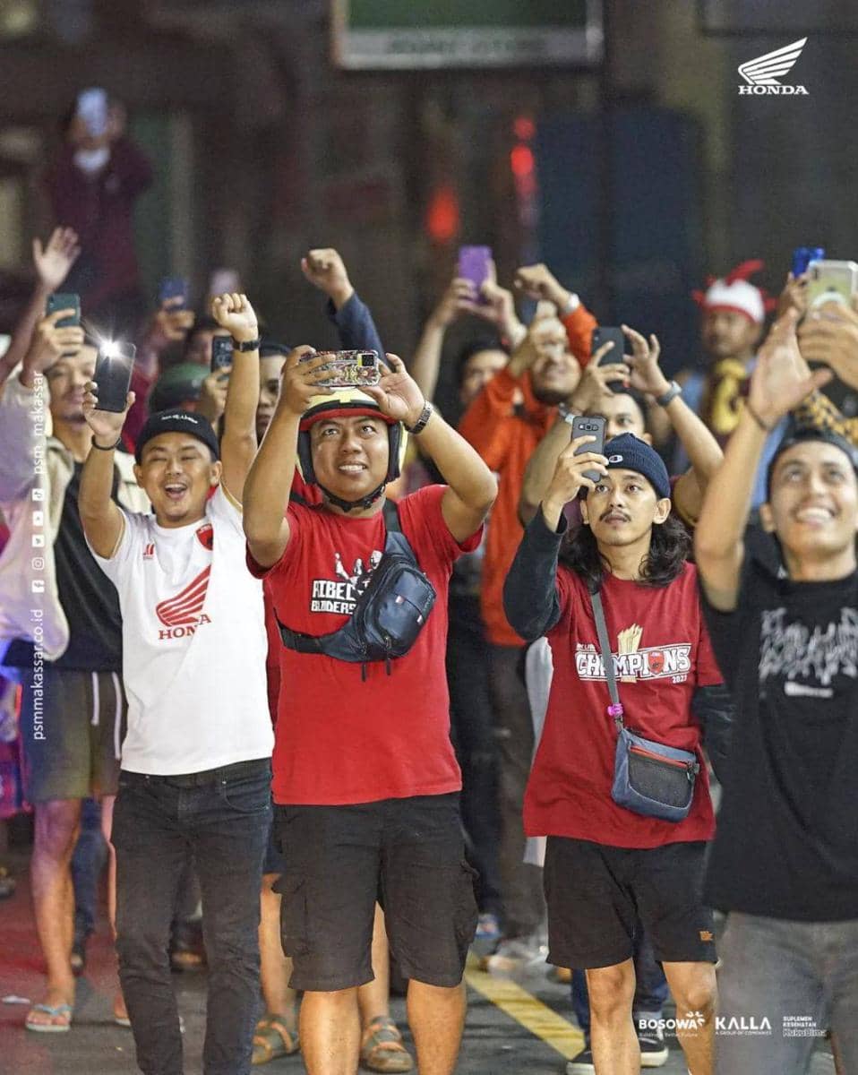 Suporter menyaksikan konvoi pemain PSM Makassar bersama trofi Liga 1 di Kota Parepare, Sulawesi Selatan, Minggu malam (16/4/2023). (Instagram/psm_makassar)