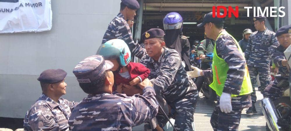 Anggota TNI AL Semarang membantu para pemudik yang membawa anaknya saat turun dari KRI Banjarmasin. (IDN Times/Fariz Fardianto (