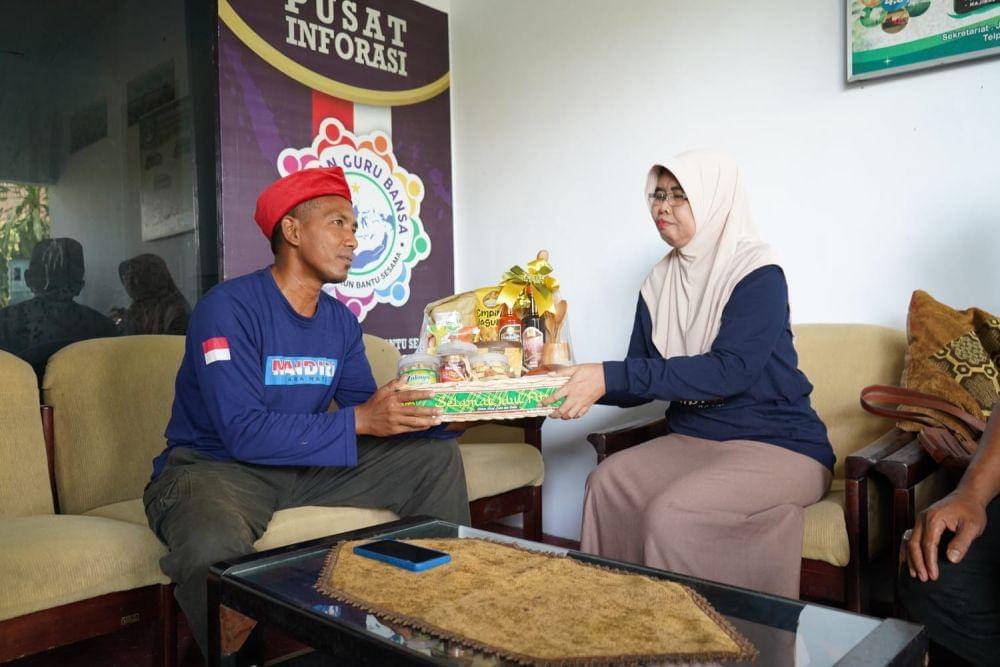 Pelaksana Tugas Kepala Dinas Sosial Kabupaten Kediri, Dyah Saktiana, memberikan hadiah parsel kepada Imam Basori, penggagas mobil reaksi cepat. (Dok. Pemkab Kediri)