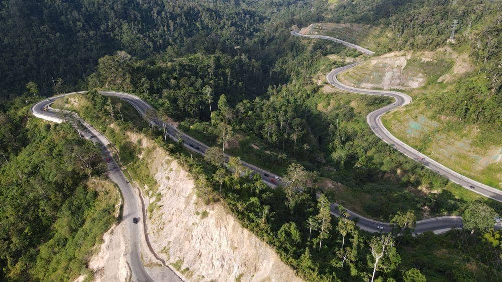 Foto udara kendaraan melintasi jalan berkelok pada jalur Trans Sulawesi Kebun Kopi di Kabupaten Parigi Moutong, Sulawesi Tengah, Selasa (18/4/2023). ANTARA FOTO/Mohamad Hamzah/hp.