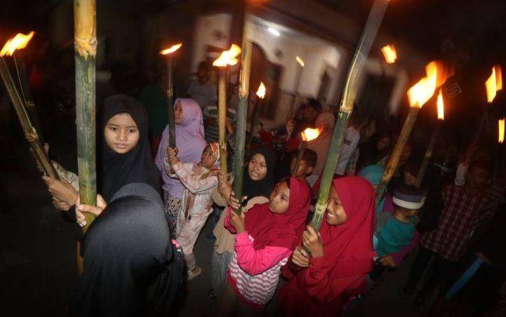 Sejumlah anak-anak membawa obor saat semarak takbir keliling di Kelurahan Ngronggo, Kota Kediri, Jawa Timur, Jumat (21/4/2023). Takbir keliling mengitari kampung setempat tersebut guna menyambut datangnya Idul Fitri 1444 H. (ANTARA FOTO/Prasetia Fauzani/hp.)