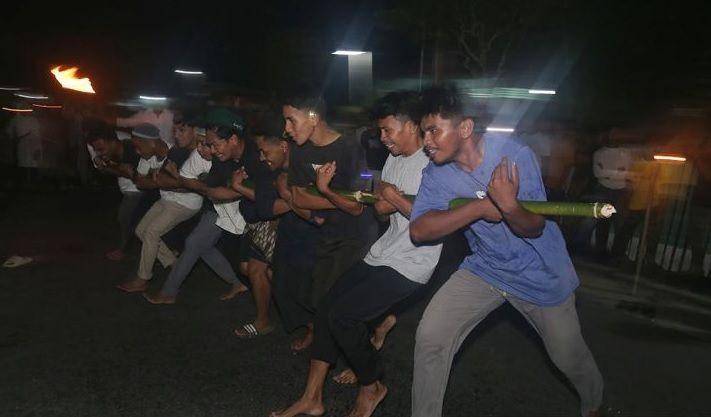 Sejumlah pemuda mengikuti atraksi bambu gila dalam festival malam Ela-ela di Desa Kupal, Pulau Bacan, Kabupaten Halmahera Selatan, Maluku Utara, Jumat (21/4/2023), untuk menyambut Idul Fitri 1444 Hijriah. (ANTARA FOTO/Andri Saputra/nym.)