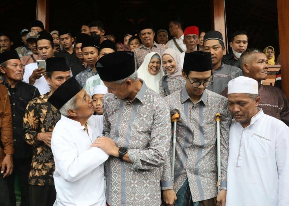 KH Ahmad Mustaid Billah Hisyam Abdul Karim seorang pengasuh Ponpes Kalijaran menggenggam erat tangan Ganjar Pranowo saat acara halal bihalal di Purbalingga. (IDN Times/Dok Humas Pemprov Jateng)