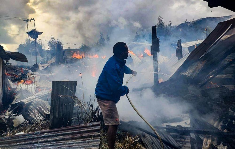 Upaya pemadaman api yang melahap bangunan bekas mess karyawan PT Unggul di Jalan Pancoran, Distrik Ilaga, Kabupaten Puncak, Papua Tengah, Jumat (28/4/2023). (IDN Times/Istimewa)