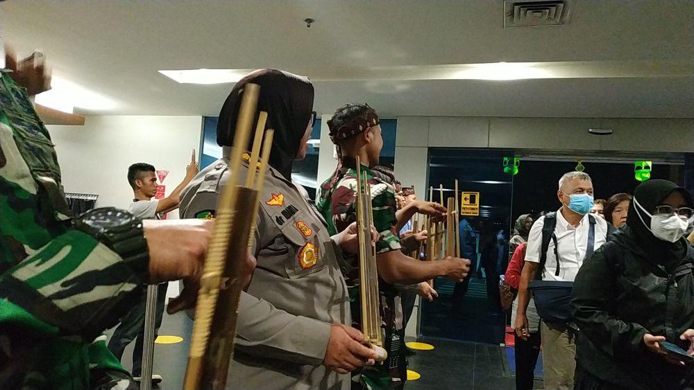Polri-TNI Sambut Penumpang di Bandara Husein dengan Alunan Angklung