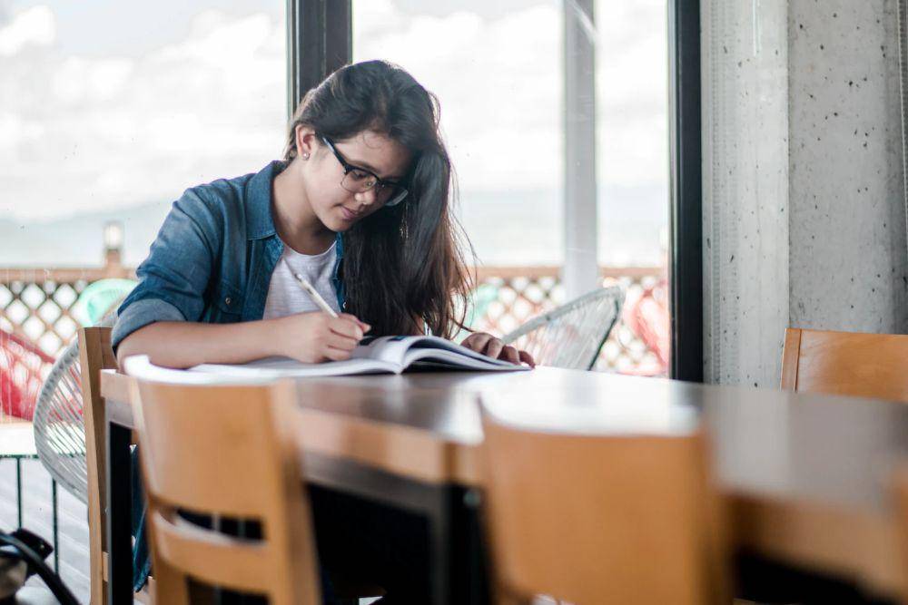 ilustrasi wanita yang sedang menulis (unsplash.com/kyledevaras)