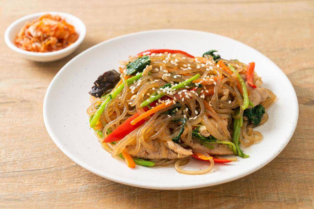 ilustrasi japchae masakan korea yang terbuat dari bihun (vecteezy.com/Natthapon Ngamnithiporn)