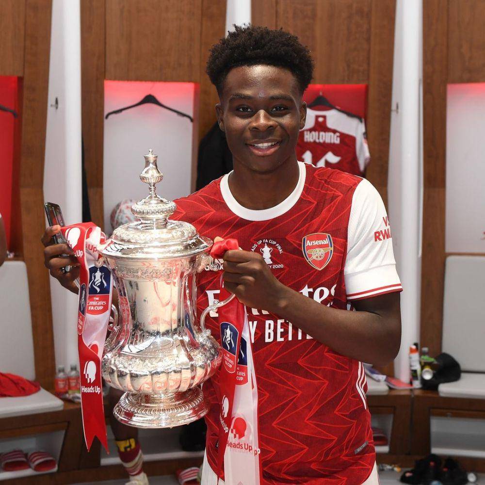 Pemain Arsenal, Bukayo Saka, berfoto dengan trofi Piala FA Cup setelah berhasil menjuarai Piala FA 2020 dengan mengalahkan Chelsea di partai final. (instagram.com/arsenal)
