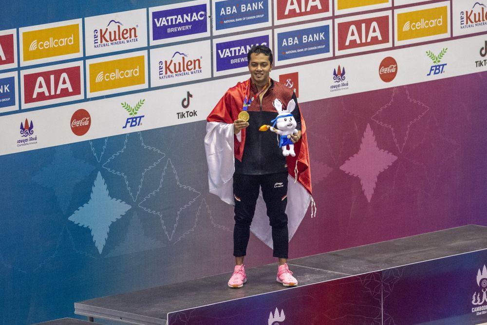 Perenang Indonesia I Gede Siman Sudartawa menunjukan medali seusai penyematan medali emas untuk nomor 50 meter gaya punggung putra saat SEA Games 2023 di Aquatics Center, Morodok Techno National Stadium, Kamboja, Minggu (7/5/2023). Siman meraih medali emas usai finis tercepat dengan catatan waktu 25,16 detik sementara perenang Filipina Jerard Dominic Jacinto meraih medali perak dengan catatan waktu 25,56 detik dan perenang Singapura Zheng Wen Quah meraih medali perunggu dengan catatan waktu 25,6