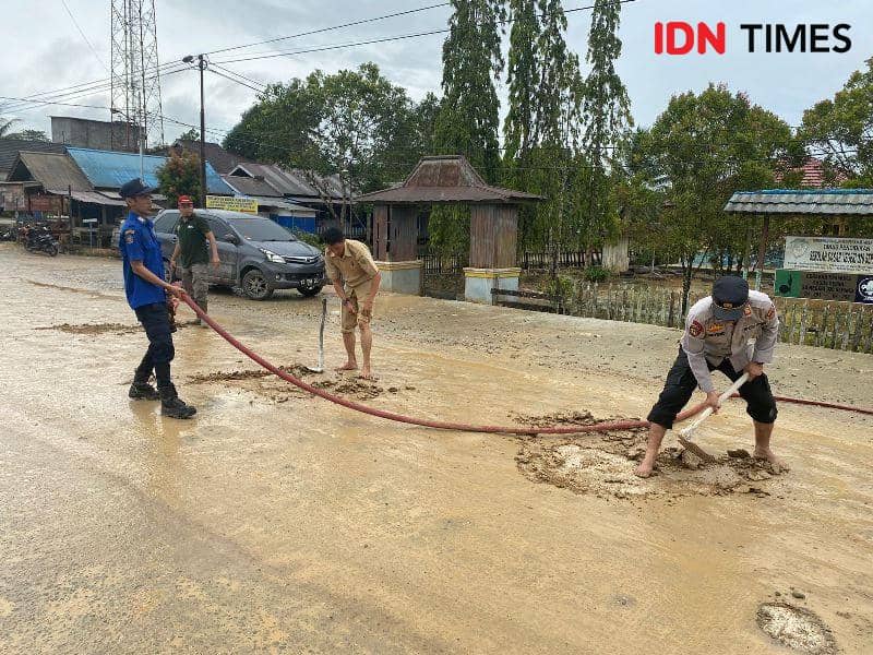 Kapolsek Sepaku AKP Kasiyono terjun langsung bersihkan jalan bersama pemadam kebarakan dan ASN Kecamatan (IDN Times/Ervan)