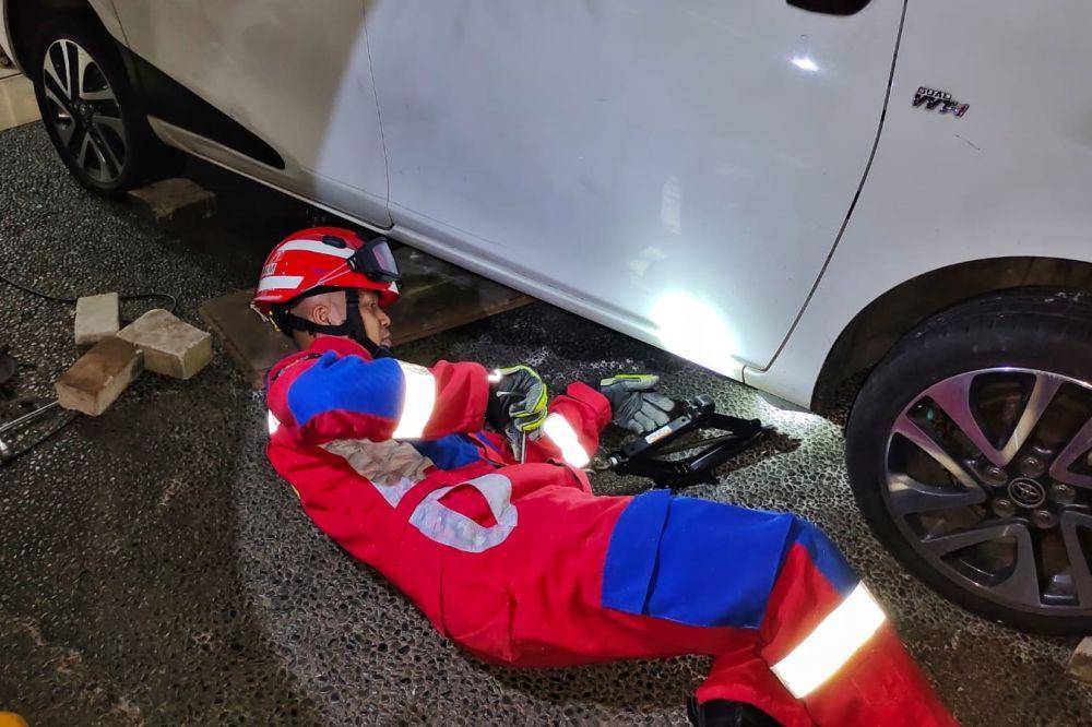 Damkar evakuasi seekor anjing yang terjebak dalam kap mobil. (dok. Damkar Jatim)