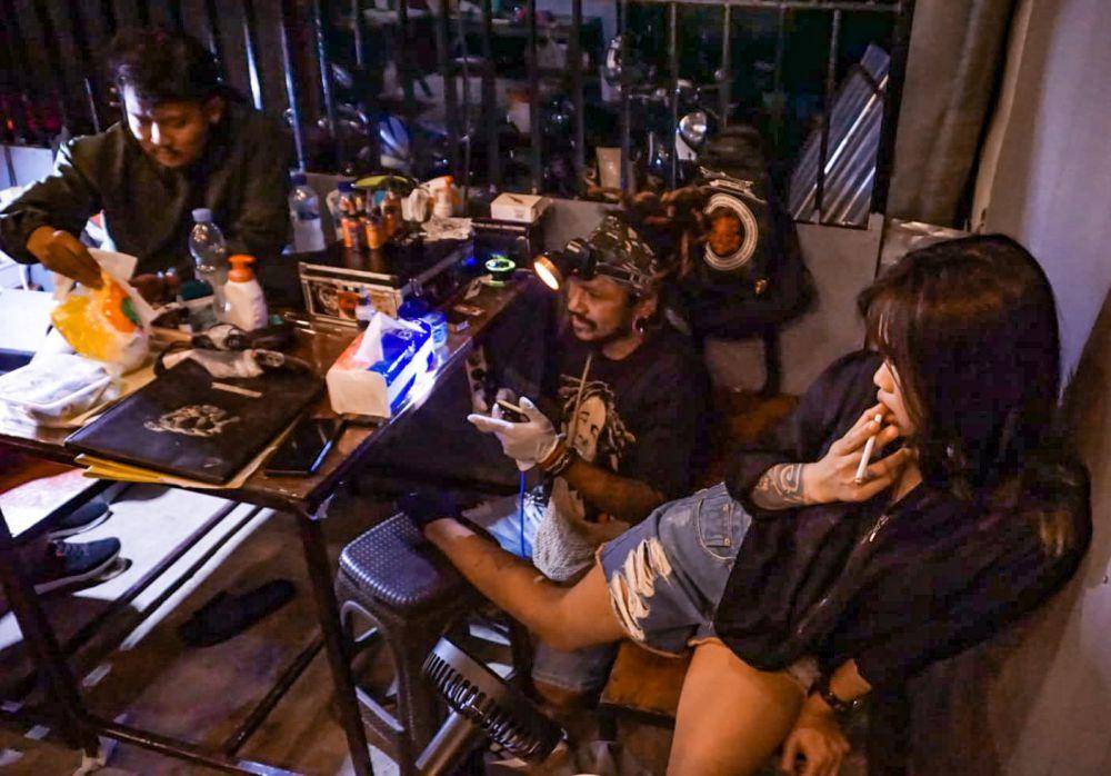 Ketua Pace Kasta, Achos Florastattoo, saat melayani customer dalam kegiatan Tattoo Show. (IDN Times/Endy Langobelen)