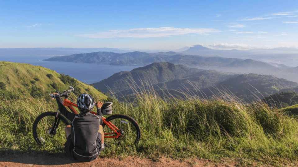 Seorang pria yang duduk di samping sepeda (pexels.com/Dó Castle)