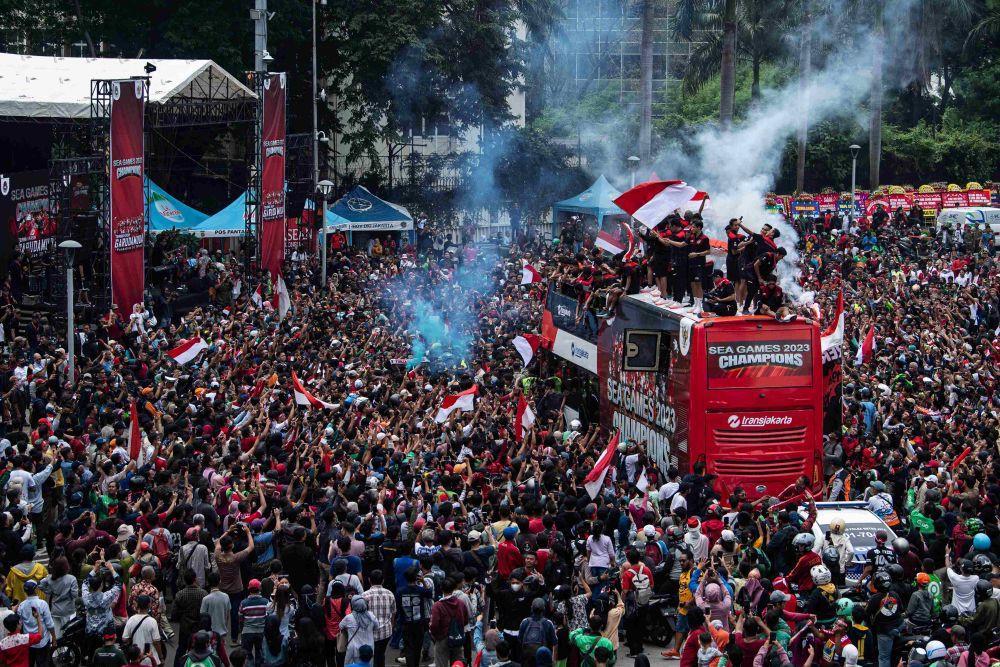 Timnas sepak bola Indonesia U-22 bersama ofisial dan pengurus PSSI berada di atas bus saat melintas dalam arak-arakan Kira87uara Kontingen SEA Games 2023 di Bundaran HI, Jakarta, Jumat (19/5/2023). (ANTARA FOTO/Sigid Kurniawan)