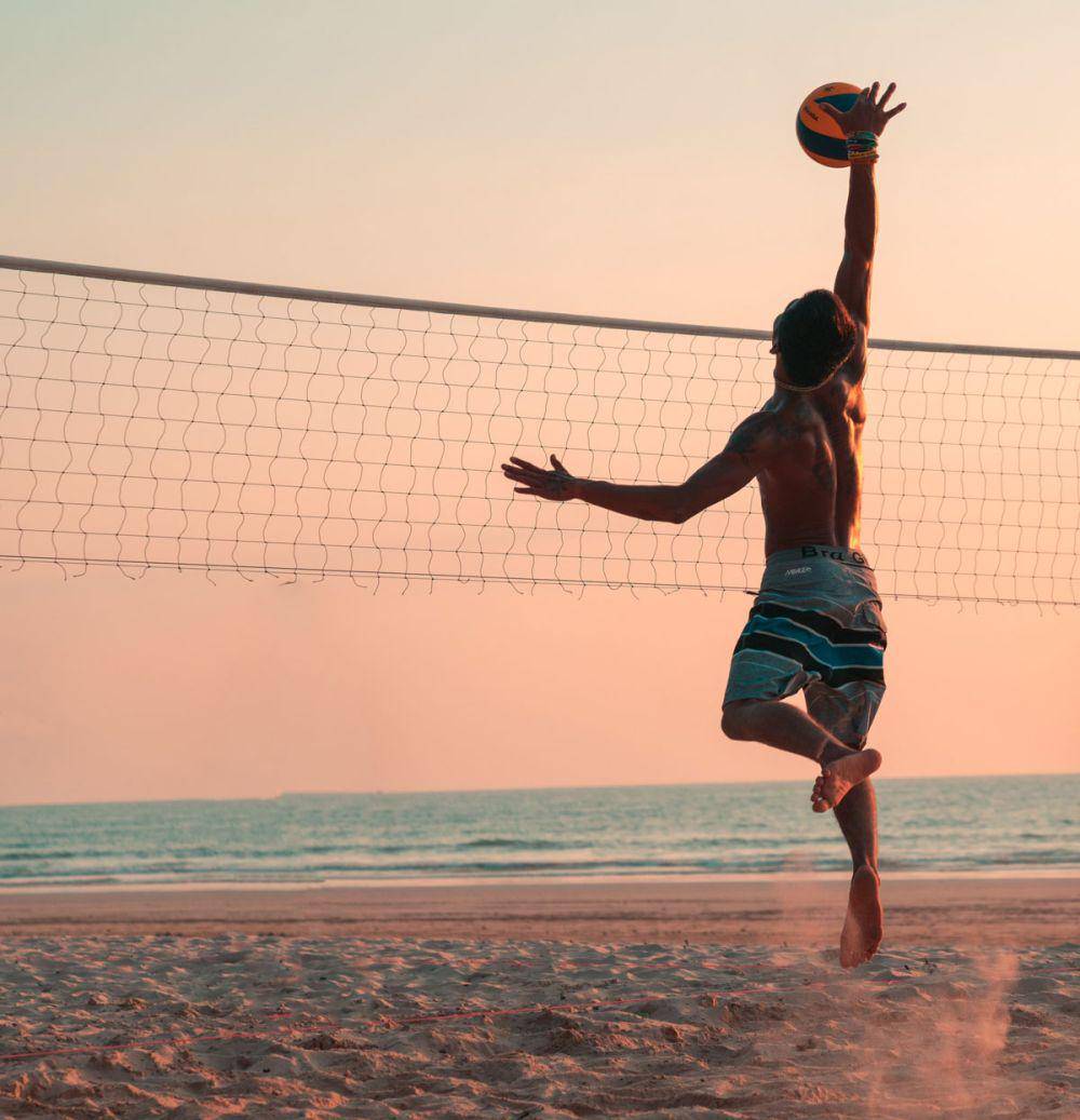 Pemain voli pantai sedang melakukan smash. (unsplash.com/Colton Duke)