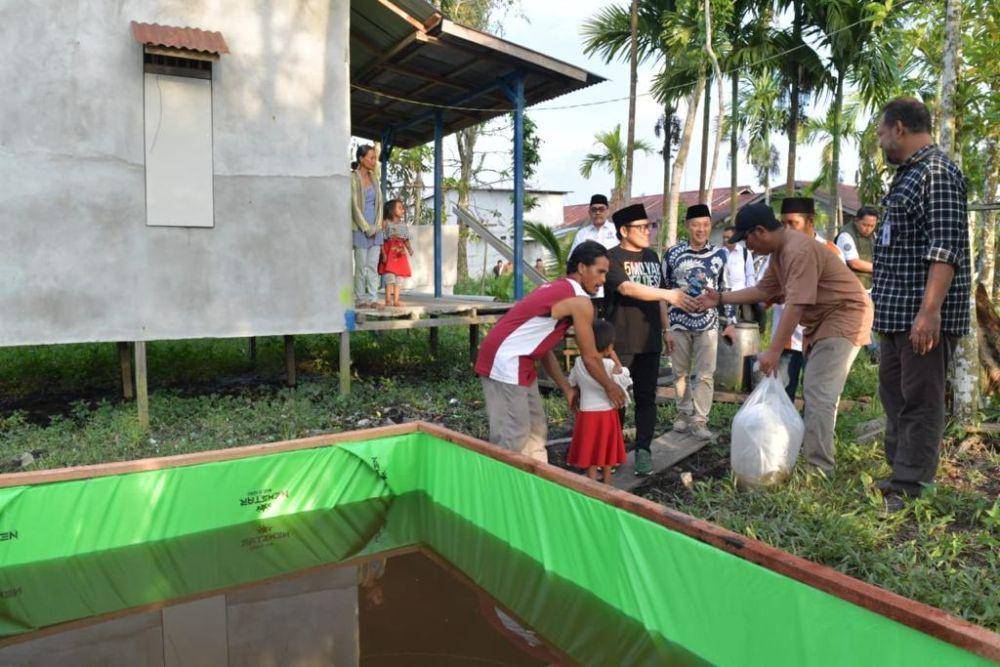 Wakil Ketua DPR RI Muhaimin Iskandar memberikan bantuan sarana produksi ternak lele kepada keluarga Maryono warga Desa Rasau Jaya Umum, Kecamatan Rasau Jaya, Kubu Raya, Kalimantan Barat, Jumat (26/5/2023). Bioflog lele ini dapat menghasilkan keuntungan bersih Rp 1,6 juta setiap panen, sehingga keluarga Maryono dapat lepas dari kemiskinan ekstrem. Istri Maryono, Nila Tri Wulandari merupakan penyandang tunawicara, memiliki delapan anak, salah satunya stunting. (Dok. Kemendes PDTT)