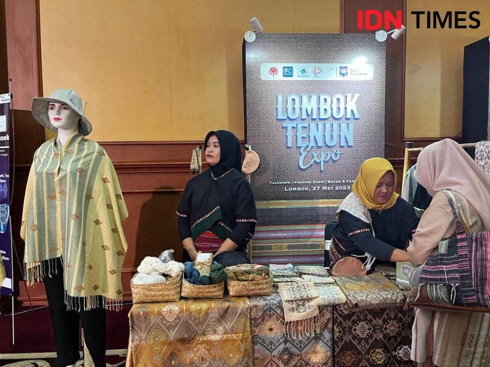 Khairun Nisa melayani pembeli kain tenun (IDN Times/Linggauni)