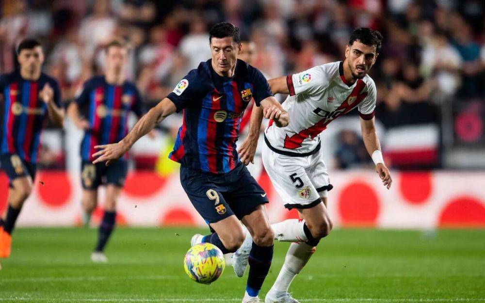Robert Lewandowski, pemain Barcelona, mencoba melewati adangan pemain Rayo Vallecano saat bersua di LaLiga 2022/2023. (fcbarcelona.com)