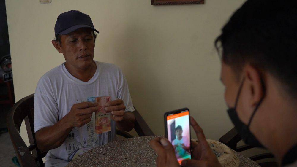Petugas Kantorpos melakukan pendataan berupa foto kepada penerima bansos yang didatangi secara door to door. (Dok. Pos Indonesia)