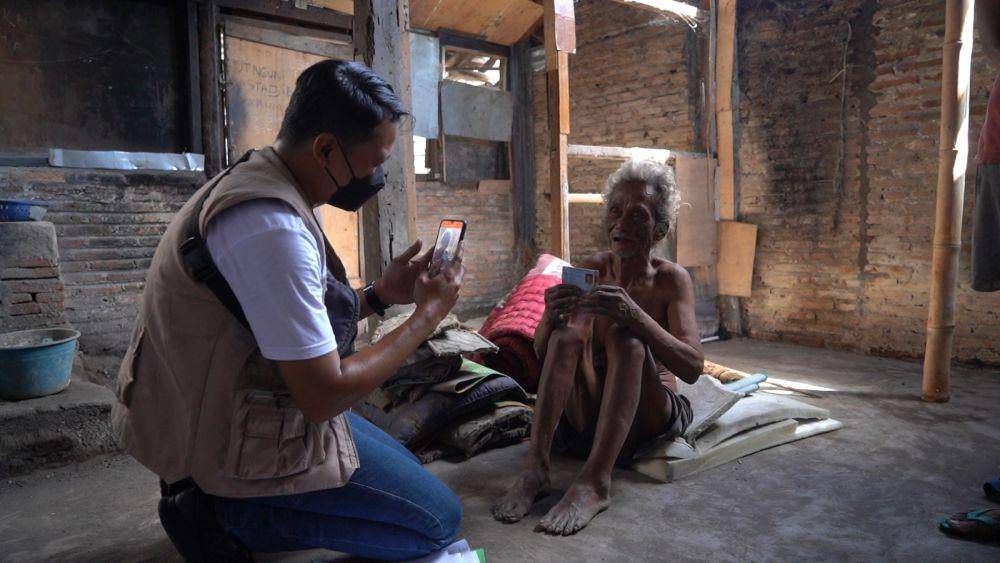 Petugas Kantorpos melakukan proses perekaman dan pendokumentasian dari biometrik dengan face recognition, dan melakukan foto tempat tinggal KPM sekaligus melakukan geotagging. (Dok. Pos Indonesia)