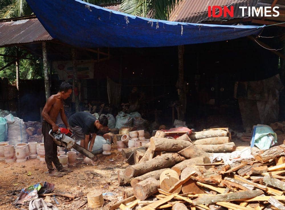 Pengrajin Klaster Maju Sejahtera memotong kayu untuk membuat lumpang (IDN Times/Doni Hermawan)