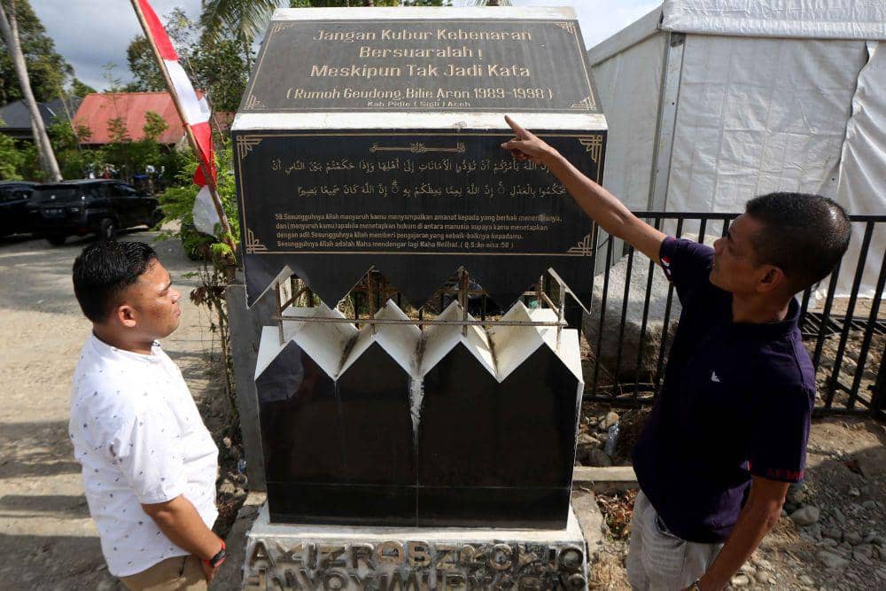 Warga melihat monumen Rumoh Geudong (rumah gedung) di Desa Bilie Aron, Kecamatan Glumpang Tiga, Pidie, Aceh, Minggu (25/6/2023). (ANTARA FOTO/Irwansyah Putra)