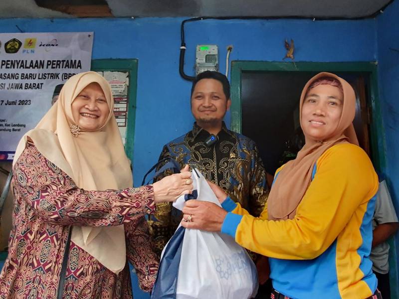 Selain menerima bantuan penyambungan listrik gratis, Juariah (kanan) juga menerima bantuan sembako dari YBM PLN yang diserahkan oleh General Manager PLN UID Jabar, Susiana Mutia (kiri) dan disaksikan oleh Anggota Komisi VII DPR RI, Rian Firmansyah (tengah)