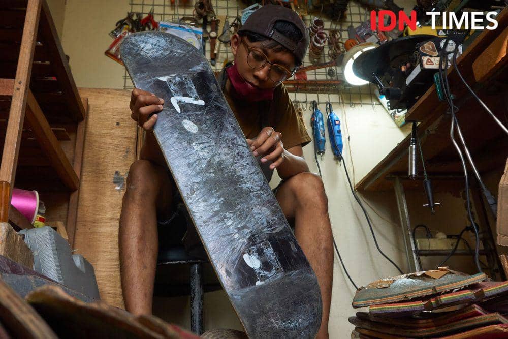 Pemilik UMKM Loosewood, Andhika Praditya (30) mengecek papan (deck) papan luncur (skateboard) untuk didaur ulang menjadi kacamata dan jam tangan di Kota Solo (IDN Times/Dhana Kencana)