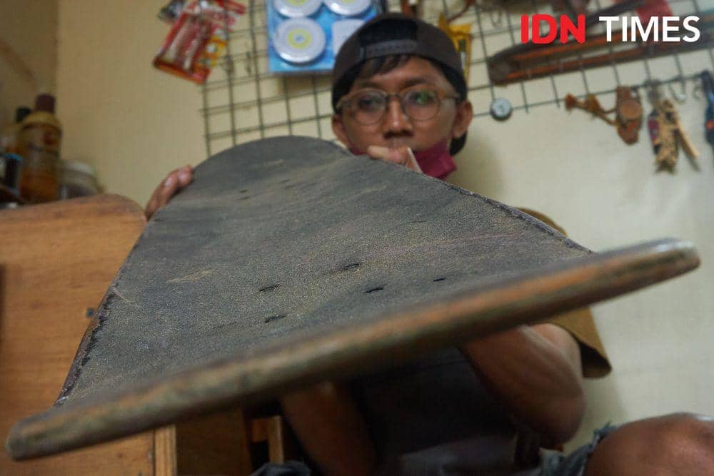 Pemilik UMKM Loosewood, Andhika Praditya (30) mengecek papan (deck) papan luncur (skateboard) untuk didaur ulang menjadi kacamata dan jam tangan di Kota Solo (IDN Times/Dhana Kencana)