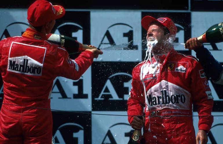 Michael Schumacher dan Rubens Barrichello merayakan hasil finis 1-2 untuk Ferrari di GP Austria 2002. (formula1.com)