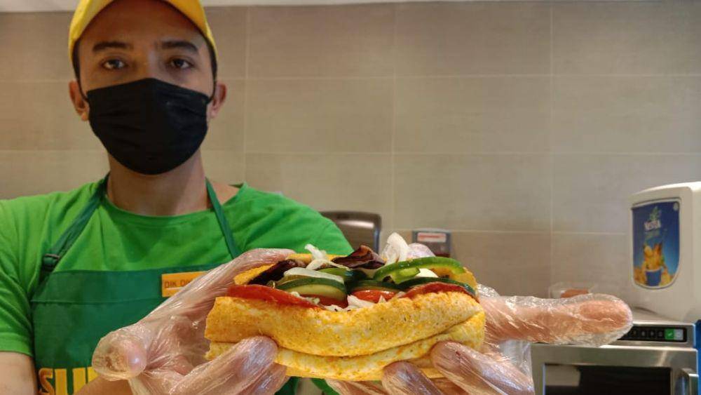 Seorang koki gerai Subway Indonesia menunjukkan sebuah varian menu bernama roast beef yang berisi potongan daging cincang yang dikombinasikan dengan saus mayones, sayuran dan lembaran keju. (IDN Times/Fariz Fardianto)