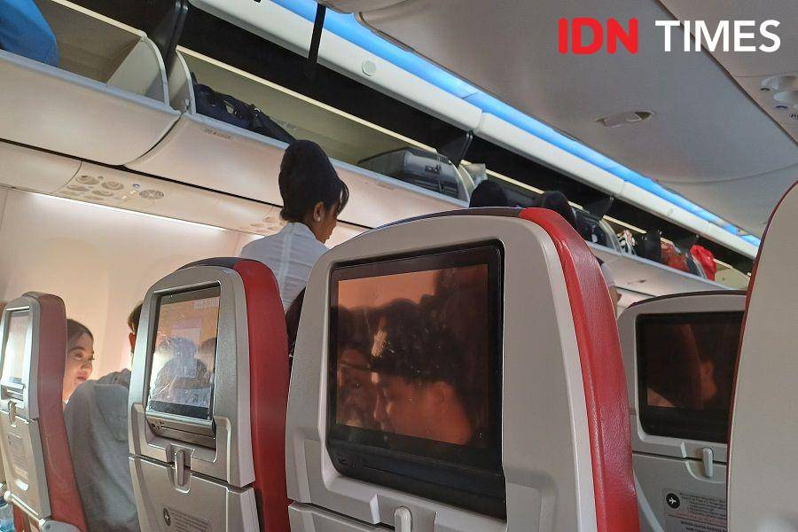 Ilustrasi pramugari melayani penumpang di dalam pesawat (IDN Times/Dhiya Awlia Azzahra)