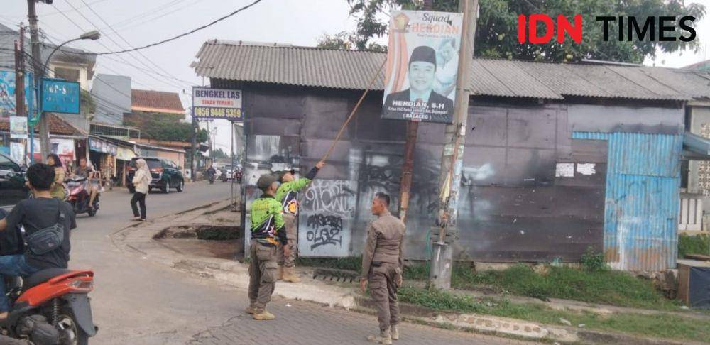 Satpol PP Kota Depok menertibkan APK Parpol dan spanduk niaga di Kecamatan Bojongsari, Kota Depok. (IDNTimes/Dicky)