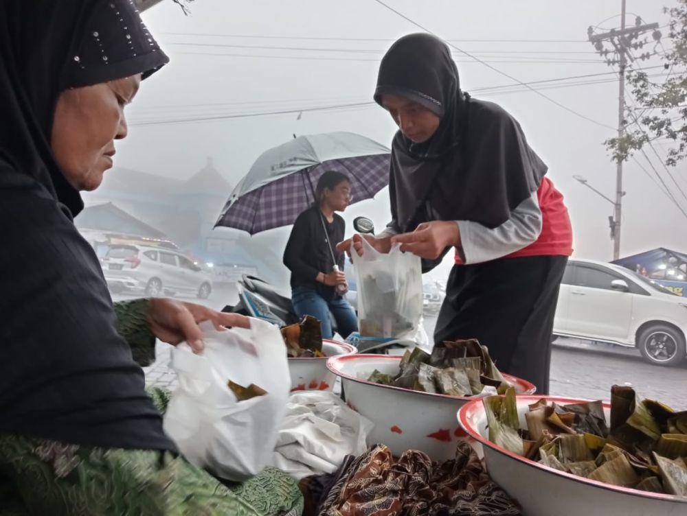 Pelanggan membeli sego Menok di pangkalan ojek terminal Plaosan Magetan. IDN Times/Riyanto