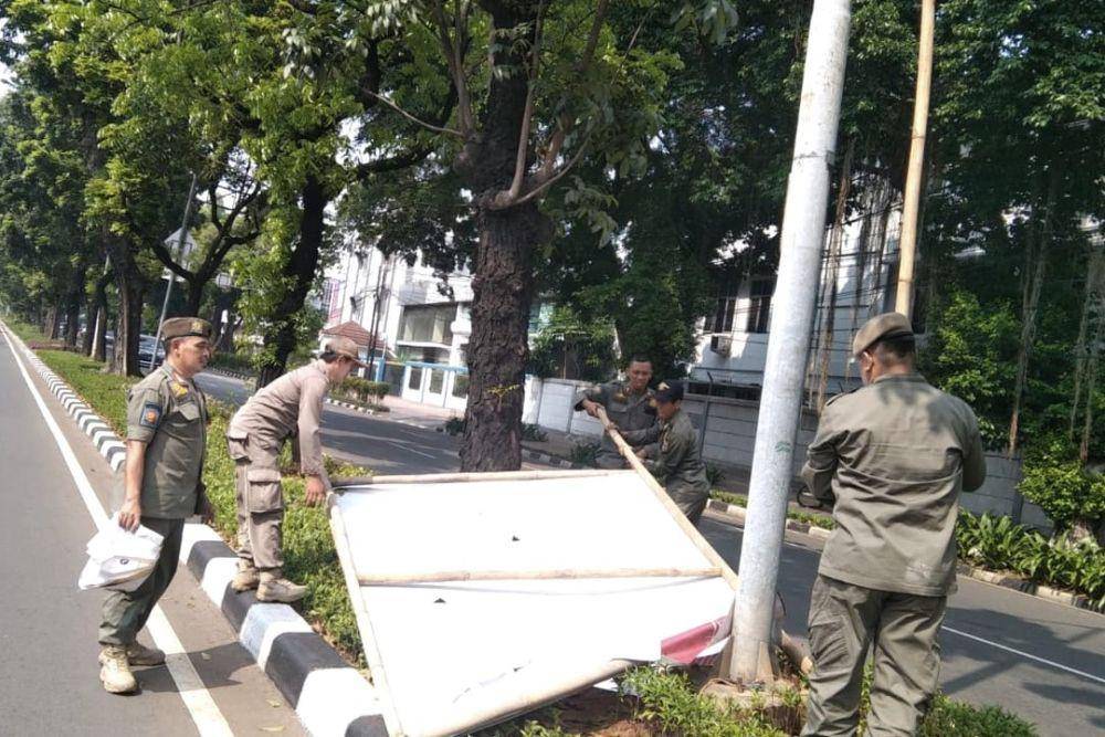 Satpol PP DKI Jakarta lepas spanduk kampanye. (dok. Satpol PP)