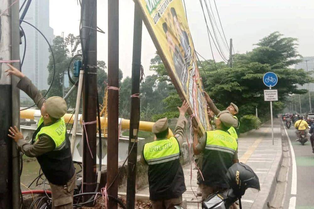 Satpol PP DKI Jakarta lepas spanduk kampanye. (dok. Satpol PP)