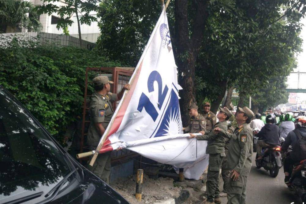 Satpol PP DKI Jakarta lepas spanduk kampanye. (dok. Satpol PP)