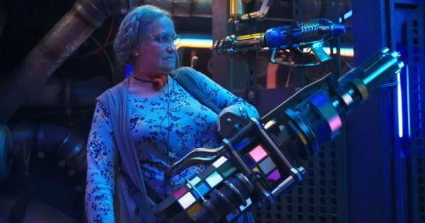 Nana memegang senjata minigun ( Dok. Warner Bros / Blue Beetle )