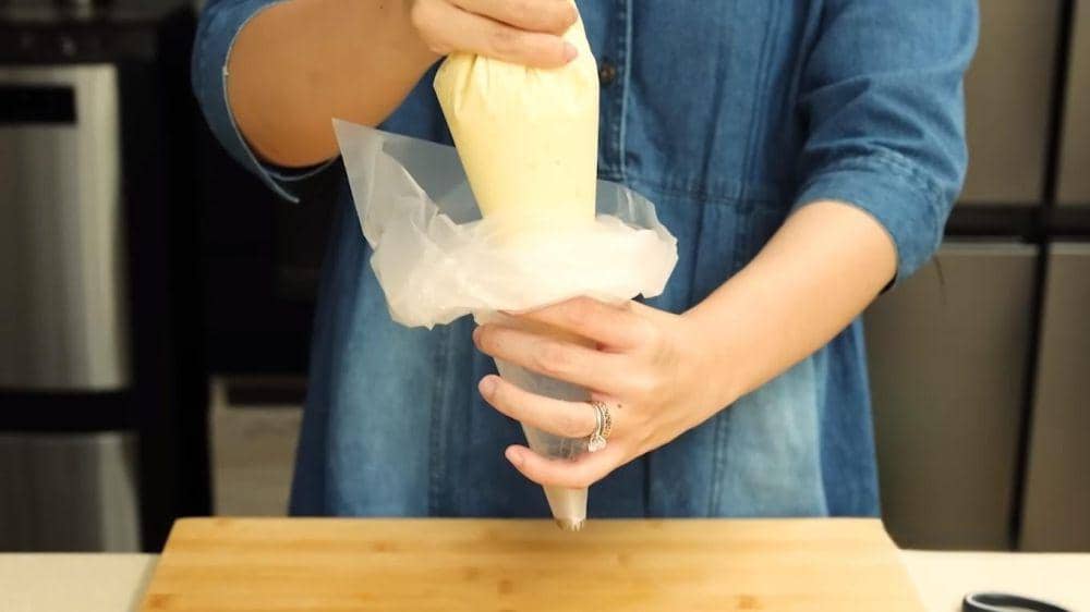 Proses menggunakan piping bag. (dok. YouTube.com/Devina Hermawan)