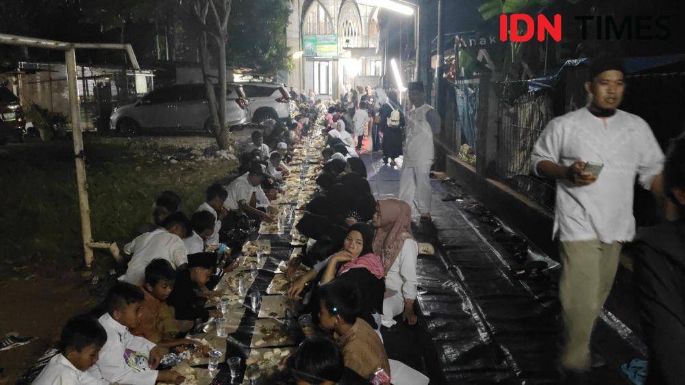 Setelah melakukan pawai obor, warga menggelar makan bersama. (IDN Times/Imam Faishal)