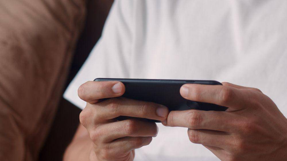 ilustrasi orang sedang bermain game smartphone (freepik.com/tirachardz)