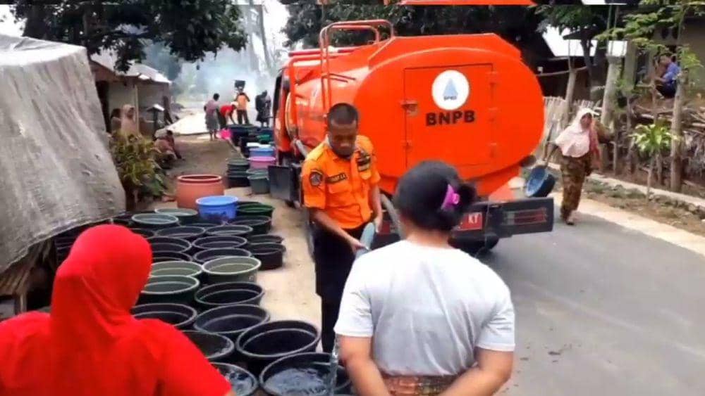 Petugas BPBD Lotim melakukan membagikan air bersih kepada warga terdampak kekeringan (dok. Pribadi/Ruhaili)