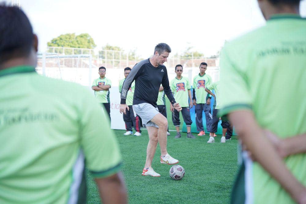 Pelatih berlisensi UEFA A, Timo Scheunemann berbagi pengalaman dan materi di antaranya seputar penguasaan bola atau ball mastery, dribbling, passing, taktik menyerang dan bertahan, hingga program latihan sesuai standar Sekolah Sepak Bola (SSB) pada kegiatan MilkLife Coaching Clinic di Supersoccer Arena, Rendeng, Kudus, Jawa Tengah, Sabtu (22/7/2023). (dok. Djarum Foundation)