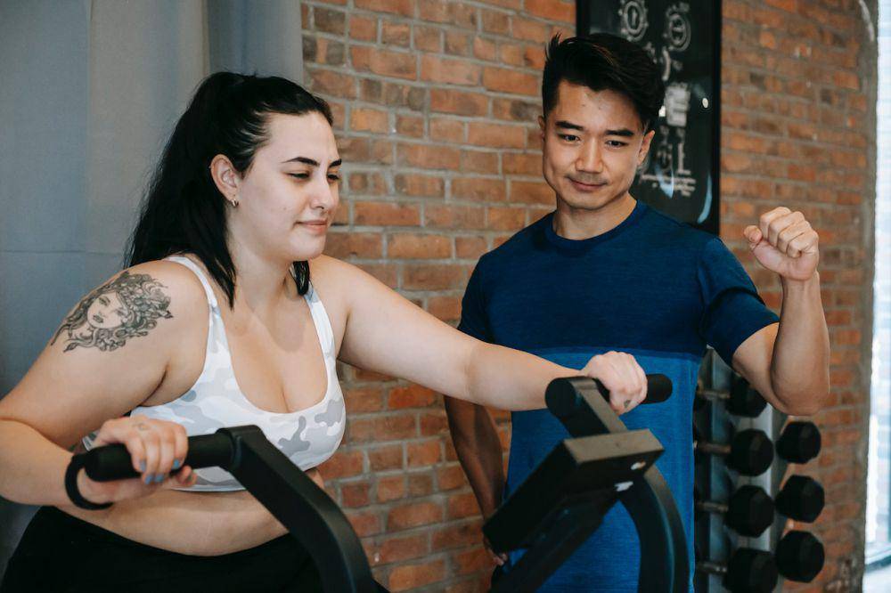 ilustrasi orang berolahraga dengan pelatih gym (pexels.com/Andres Ayrton)