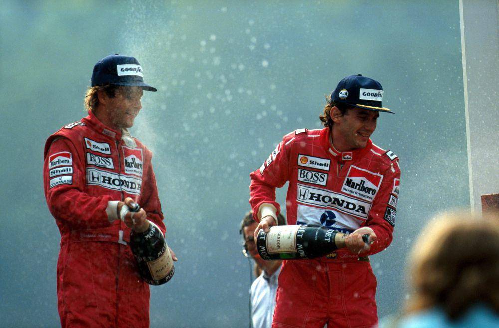 Ayrton Senna merayakan kemenangan GP Belgia 1990 bersama rekannya di McLaren, Gerhard Berger, yang finis di podium ketiga. (twitter.com/McLaren)