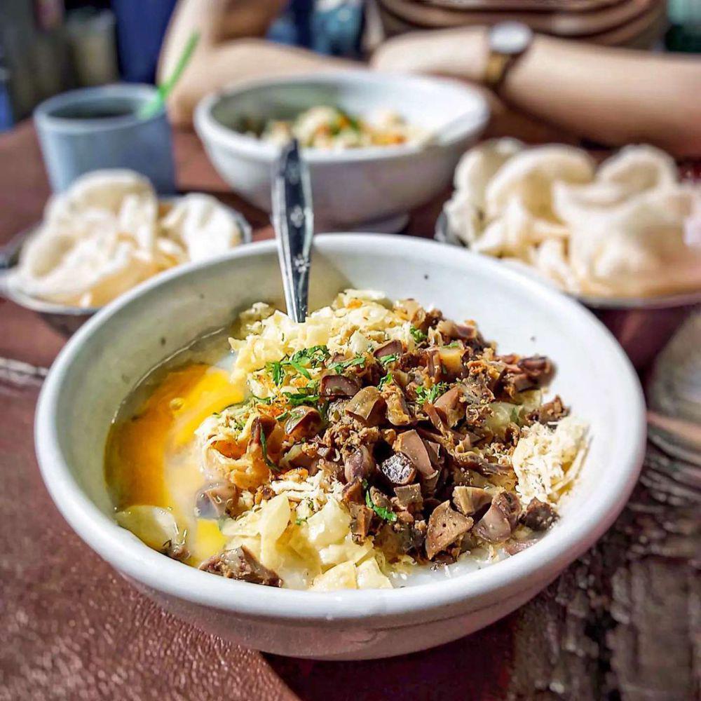 Semangkok bubur ayam Mang Dudung ditambah telor setengah matang. Instagram/foo.ga